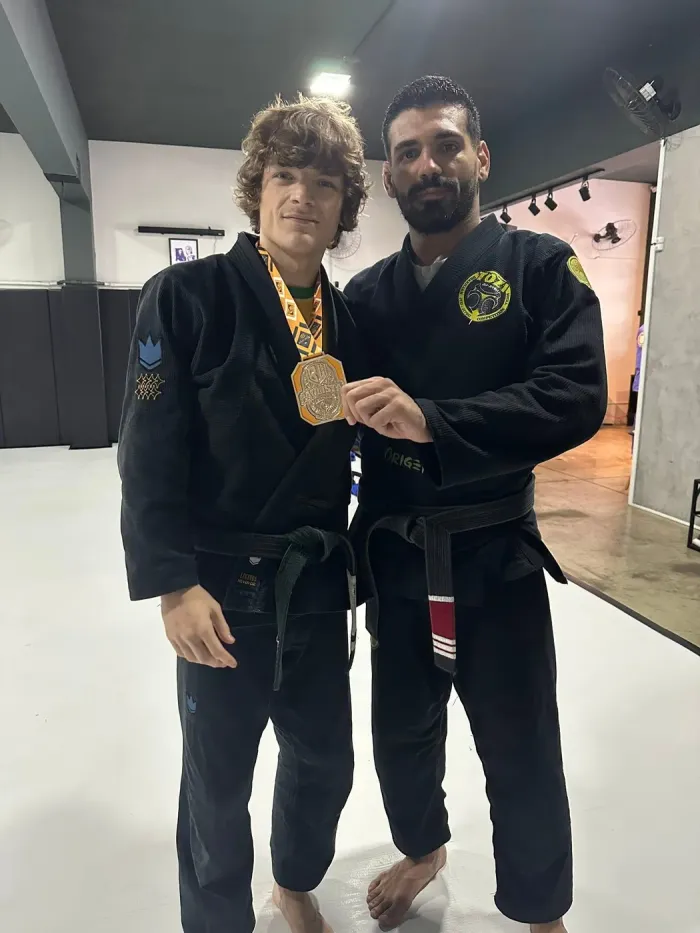 Tyler with his coach and a competition medal